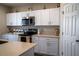 A well-lit kitchen featuring white cabinets, stainless steel appliances, and countertop decor at 3440 Dahlia Dr, Haines City, FL 33844