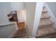 Carpeted staircase going down, with partial view of kitchen and dining area at 3440 Dahlia Dr, Haines City, FL 33844