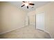 Empty bedroom featuring tile floors, a ceiling fan, and a closet with mirrored doors at 3565 Raleigh Dr, Winter Haven, FL 33884