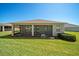 Rear exterior view of home showing screened in lanai, manicured lawn, and mature shrubbery at 3565 Raleigh Dr, Winter Haven, FL 33884