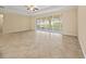 Spacious living room featuring neutral paint, tile flooring, and sliding doors leading to the outdoors at 3565 Raleigh Dr, Winter Haven, FL 33884