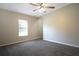 Cozy bedroom featuring neutral walls, ceiling fan, and window for natural light at 3611 Island Oaks Ct, Lakeland, FL 33805
