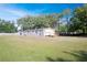 Home with spacious lawn, deck and mature trees under sunny sky at 3611 Island Oaks Ct, Lakeland, FL 33805