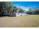 Wide view capturing house with neutral siding, set on a large lot with mature trees at 3611 Island Oaks Ct, Lakeland, FL 33805
