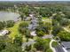 Beautiful aerial view of an estate home featuring a pool, manicured lawns, mature trees, and lake access at 3826 Gaines Ct, Winter Haven, FL 33884