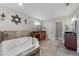 Bright bathroom featuring a soaking tub with travertine tile surround and double sink vanity at 3826 Gaines Ct, Winter Haven, FL 33884