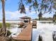 Private boat dock featuring a covered boat lift and seating, perfect for enjoying waterfront activities at 3826 Gaines Ct, Winter Haven, FL 33884