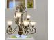 Close-up of an ornate chandelier with decorative metalwork and glass shades, adding a touch of elegance to the home at 3826 Gaines Ct, Winter Haven, FL 33884
