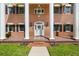 Charming brick home featuring a classic facade with prominent white columns, shutters, and a meticulously landscaped front yard at 3826 Gaines Ct, Winter Haven, FL 33884
