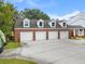 Attached four-car garage with brick exterior and white doors, providing ample parking and storage at 3826 Gaines Ct, Winter Haven, FL 33884