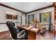 Well-lit office space featuring hardwood floors, custom built-ins, and a comfortable seating area at 3826 Gaines Ct, Winter Haven, FL 33884