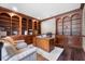 Spacious home office featuring custom wood bookshelves, a large desk, and comfortable seating for a productive workspace at 3826 Gaines Ct, Winter Haven, FL 33884