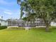 Screened-in pool area with manicured landscaping and mature trees at 3826 Gaines Ct, Winter Haven, FL 33884