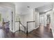 A bright upstairs hallway features dark hardwood floors, a staircase with white banisters, and an abundance of natural light at 3826 Gaines Ct, Winter Haven, FL 33884