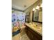 Fun bathroom with cute mermaid themed shower curtain and granite countertop vanity at 3851 Horizon View Loop, Lakeland, FL 33813