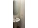 Small bathroom featuring a pedestal sink and a round mirror at 386 Feltrim Reserve Blvd # 386, Davenport, FL 33837