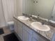 Bathroom featuring dual sinks, white cabinets, and granite countertops at 386 Feltrim Reserve Blvd # 386, Davenport, FL 33837