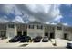 Well-maintained townhomes with a row of garages under a partly cloudy sky at 386 Feltrim Reserve Blvd # 386, Davenport, FL 33837