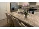 Kitchen island featuring bar seating, granite counter, and stainless appliances at 386 Feltrim Reserve Blvd # 386, Davenport, FL 33837