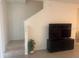 Modern living room with a large TV, staircase, and sleek design at 386 Feltrim Reserve Blvd # 386, Davenport, FL 33837