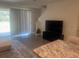 Modern living room with a large TV, staircase, and sliding glass door to the outdoors at 386 Feltrim Reserve Blvd # 386, Davenport, FL 33837