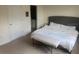 Bright main bedroom with neutral carpet, a bench at the foot of the bed and a door to the bathroom at 386 Feltrim Reserve Blvd # 386, Davenport, FL 33837