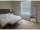 Bright main bedroom with neutral carpet, a bench at the foot of the bed and a mirror at 386 Feltrim Reserve Blvd # 386, Davenport, FL 33837