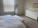 Bright main bedroom with neutral carpet, a bench at the foot of the bed, and a dresser at 386 Feltrim Reserve Blvd # 386, Davenport, FL 33837