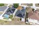 Aerial view of the house and neighborhood, roof showcasing solar panels, and backyard pool at 404 Rio Grande Ct, Poinciana, FL 34759