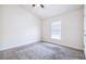 A cozy bedroom featuring neutral carpeting, a ceiling fan, and a window providing natural light at 404 Rio Grande Ct, Poinciana, FL 34759