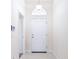 Bright entryway featuring a white door with transom window, neutral walls, and sleek, tiled flooring at 404 Rio Grande Ct, Poinciana, FL 34759