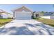 Inviting single-story home with a two-car garage, manicured lawn, and an ADT security system displayed at 404 Rio Grande Ct, Poinciana, FL 34759