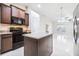 Modern kitchen with granite countertops, dark cabinetry, stainless steel appliances, and island with pendant lighting at 404 Rio Grande Ct, Poinciana, FL 34759