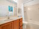 Bright bathroom with a wooden vanity, a large mirror, and a shower/tub combination at 4148 Dunmore Dr, Lake Wales, FL 33859
