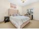 Cozy bedroom featuring a plush bed, neutral decor, and a window with plantation shutters at 4148 Dunmore Dr, Lake Wales, FL 33859