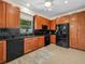 Well-equipped kitchen features granite countertops, wooden cabinets, and black appliances at 4148 Dunmore Dr, Lake Wales, FL 33859
