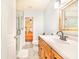 Bathroom with clear glass shower door, wood cabinet, large mirror and tile flooring at 4228 Nandina St, Lake Wales, FL 33898