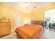 Sunny bedroom with a ceiling fan, wood floors, and view into an adjacent living room at 4228 Nandina St, Lake Wales, FL 33898