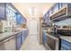 Charming kitchen featuring blue cabinets, stainless appliances, tile floors and stone backsplash at 4228 Nandina St, Lake Wales, FL 33898