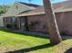 Side exterior view showcasing the brick facade, well-maintained lawn, and garden bed at 423 Greenfield Rd, Winter Haven, FL 33884