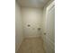 Compact laundry area with tiled flooring, utility connections, and a white door at 4333 Pumice Dr, Lakeland, FL 33811
