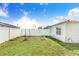 Backyard with white fence, garden boxes, and a shed with a turquoise door at 498 W 7Th St, Frostproof, FL 33843