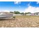 Large backyard with a boat on a trailer, trampoline, play set, privacy fence, and mature trees at 498 W 7Th St, Frostproof, FL 33843