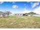 Expansive backyard featuring a trampoline, playhouse, covered patio, and plenty of green space at 498 W 7Th St, Frostproof, FL 33843