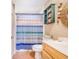 Cozy bathroom featuring a vanity, toilet, and tiled shower with a decorative curtain at 498 W 7Th St, Frostproof, FL 33843