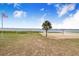 Scenic beach access with American flag, palm tree, sandy shore, and beautiful lake views at 498 W 7Th St, Frostproof, FL 33843