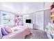 Bedroom features pink comforter and white walls, complimented by natural light and storage at 498 W 7Th St, Frostproof, FL 33843