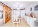 Dining room with tiled floors, barn door, modern chandelier and white wood table at 498 W 7Th St, Frostproof, FL 33843