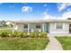 Inviting front porch featuring seating and a beautifully landscaped garden, perfect for relaxing at 498 W 7Th St, Frostproof, FL 33843