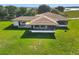 Aerial view of a single story house with a porte-cochere, screened-in porch, and lush green surroundings at 553 Thornburg Rd, Babson Park, FL 33827